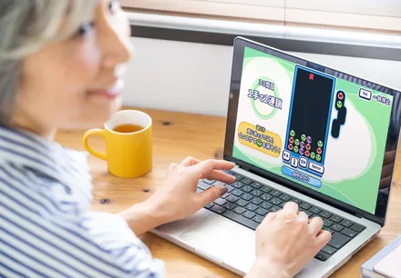 ノートパソコンで「ぷよぷよトレーナー」のドリルに取り組む女性の横顔（利用イメージ）
